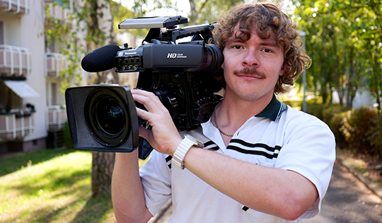 Luca Schmidli, Kameramann bei Ballentin Video, mit professioneller Videokamera