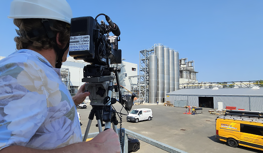 Kamerateam bei Videoaufnahmen auf einem Industriegelände