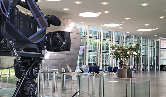 Professionelle Kamera bei Videoaufnahmen in einem modernen Unternehmensgebäude