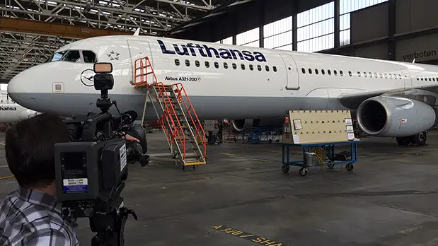 Imagefilm für Industrie und Luftfahrt Kamerateam bei Dreharbeiten an einem Verkehrsflugzeug in einem Wartungshangar für einen Unternehmensfilm