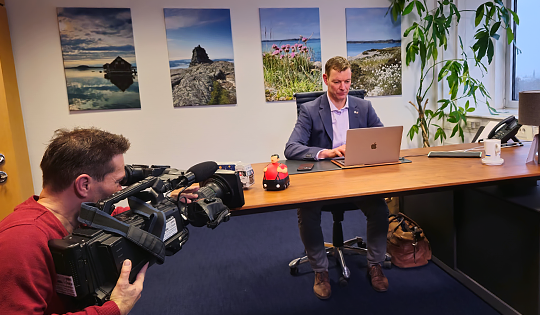 Kurzvideos mit Mitarbeitern und Experten im Unternehmen Kameramann bei Videoaufnahmen eines Mitarbeiters im Büro