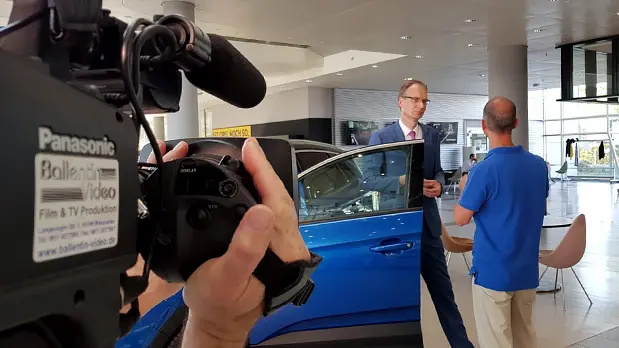 Professionelle Dreharbeiten für ein Werbevideo Kameramann bei Dreharbeiten mit Gesprächspartnern in einem Autohaus